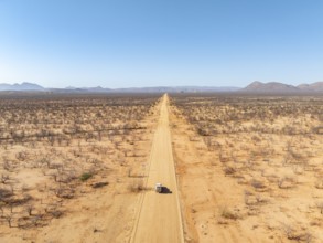 Travel, aerial view, car driving on road through arid landscape, Kunene region, Namibia