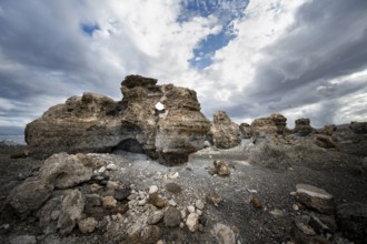 Eroded rock formations in volcanic landscape with dramatic cloudy skies, Ciudad Estratificada or