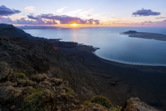 View from steep cliffs to sea and coast with sun stars, Mirador del Porrito viewpoint at sunset,