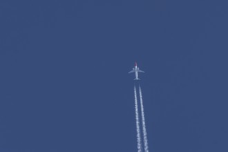 Boeing 737 jet passenger aircraft of Norwegian Air airlines flying in a blue sky with contrails or
