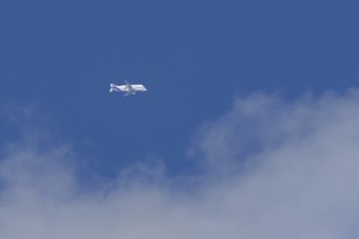 Airbus A330-743L Beluga XL cargo jet aircraft flying in a blue sky with white clouds, England,