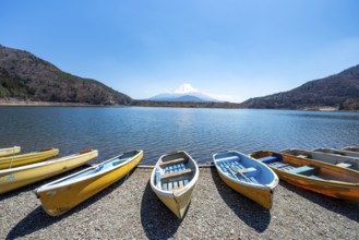 Rowing boats on shore, view across the lake to Mt Fuji volcano, Motosu Lake, Yamanashi Prefecture,