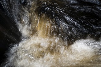 Stream flow with dark water, reflections and turbulences, long exposure, Sweden