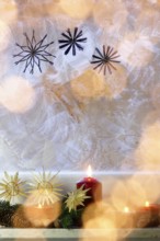 Christmassy decorated iced window, candle light, straw stars, Germany