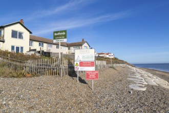 For Sale estate agent signs outside houses at risk of coastal erosion, Thorpeness, Suffolk, North