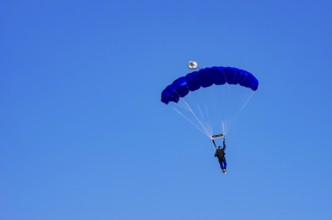 Skydivers during an aerial acrobatic performance as part of an air show at the Fliegerbergfest of