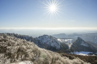 View over the hills and valleys from the mountain with hoarfrost on the branches in winter, Vápec,