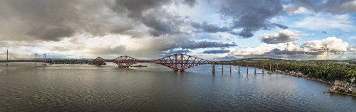 Sunset Panorama of Rain clouds over Forth Bridge from a drone, Queensferry Crossing, Forth Estuary,