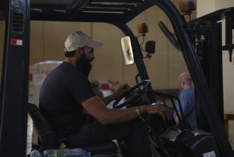 Relief workers unload boxes of medical aid provided by Qatar at Damascus International Airport,