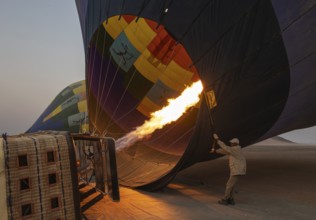 In order to get ready for the take-off, the pilot inflates the balloon with hot air by activating