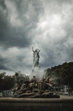 Undine Fountain with dramatic sky in the spa garden Baden, Lower Austria, Austria