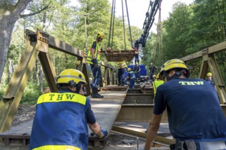 Construction of a temporary bridge over a slipped road crossing a stream, by the bridge