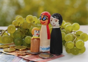 Wooden cone family with grapes and coins and banknotes, North Rhine-Westphalia, Germany