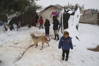 Displaced Syrian families and children living in refugee camps during harsh winter conditions,
