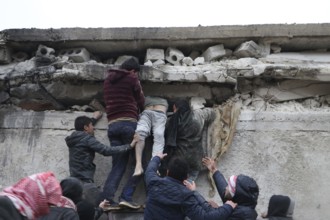 Civil defense teams attempt to rescue civilians trapped under the rubble after a powerful