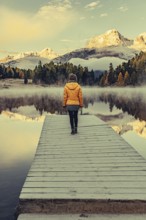 Young woman at Lake Staz near Sankt Moritz in the Engadine in Switzerland. Morning atmosphere with