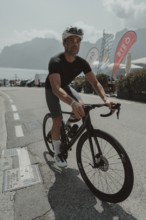 Young man riding a racing bike on Lake Garda. Sunny weather and dolce vita