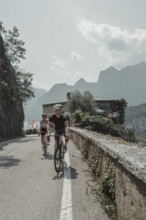 Woman and man cycling on Lake Garda in Italy. Sunny weather and dolce vita