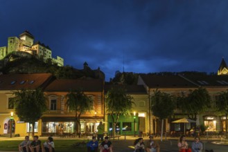 Night shot of the Peace Square in the historic centre of Trencín, Trencín Castle in the background,