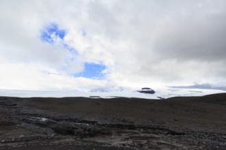 Black volcanic landscape with remnants of snow, Langjökull glacier, Husafell, Iceland