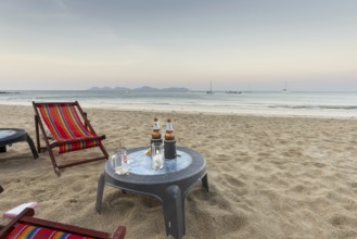 Abandoned deckchairs and parasol after sunset at Charlie Beach, Koh Mook Island, Andaman Sea,
