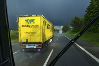 Overtaking manoeuvre of articulated lorry, lorry overtaking in thunderstorm, heavy rain, poor