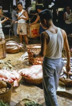 Weighing baskets of fish at the old fish market, Johor Bahru, Malaysia, Southeast Asia 1963