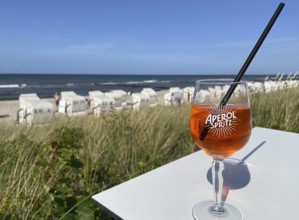 Glass of Aperol Spritz on a table overlooking the beach, Baltic resort Kühlungsborn,