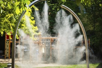 A mobile spray arch sprays fine water mist in a park in Bratislava, Slovakia