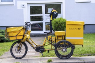 Postman, Deutsche Post, distributes the mail in an apartment building, electric tricycle, North