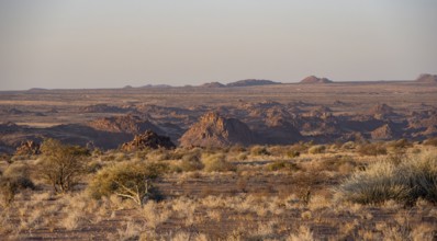 Desert landscape in the evening light at sunset, barren landscape with hills of stacked rocks,