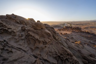 Eroded rock formations at sunrise with sun star, Erongo, Damaraland, Namibia