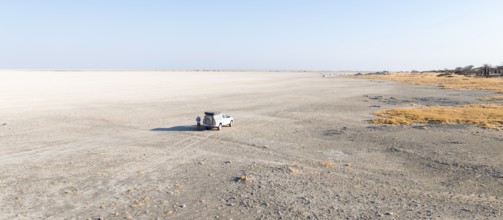 Dry salt pan, off-road vehicle on the salt pan, aerial view, Kubu Island, Botswana