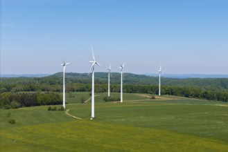 Several wind turbines on extensive meadows with forest in the background, Swabian Alb,