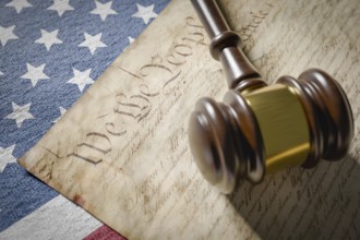 United states constitution, gavel and american flag resting on table