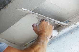 Plasterer smoothing and levelling interior walls