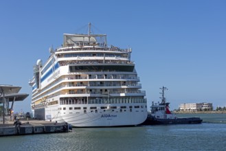 Cruise ship AIDA nova is pushed against the quay wall by tugboats, Warnow, Warnemünde, Rostock,