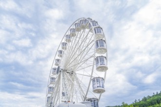 Ferris wheel in full height in front of a cloudy sky, Ferris wheel construction for the 950th