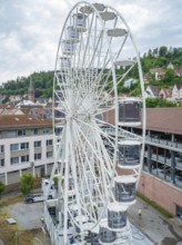 A large Ferris wheel in an urban environment with a cloudy sky, Ferris wheel construction for the