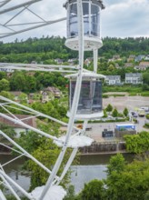 Ferris wheel view of a river, surrounded by green hills and a cityscape, Ferris wheel construction