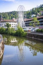 White Ferris wheel reflected in the river with surrounding buildings, Ferris wheel construction for