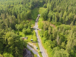Green forest landscape with railway tracks and tunnel, nature surrounds the line, construction of