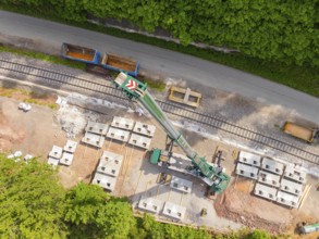 Industrial structure from the air with railway tracks and concrete blocks adjacent to a road,