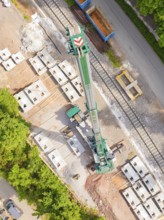 A crane on a building site, surrounded by rails and materials, construction of the Hermann Hesse