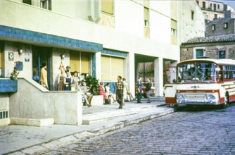 People outside hotel waiting to board tour bus coach, Piazza Armerina, Sicily 1960s