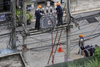 Electricians working on power lines, Pattaya, Thailand