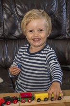 Blond boy, 2 years old, playing with toy train in Ystad, Skåne County, Sweden, Scandinavia