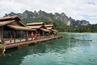Floating houses on lake with jungle and rainforest and steep mountains, Cheow Lan Lake, Khao Sok