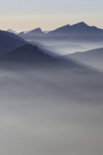 Mountain silhouettes... Alpine peaks and mountain ranges in the Bavarian Alps, light fog rises from