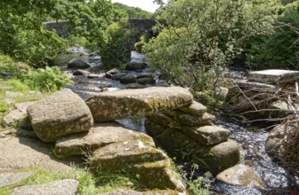 Remains of an old stone bridge and the new bridge on the East Dart River in Dartmoor National Park.